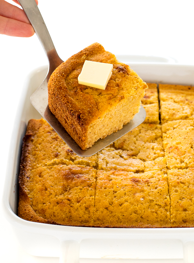 Super Easy Cornbread using a spatula to get a square of cornbread with butter on top