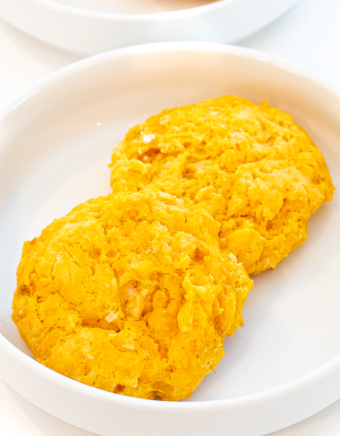 Two sweet potato biscuits on a white plate. 