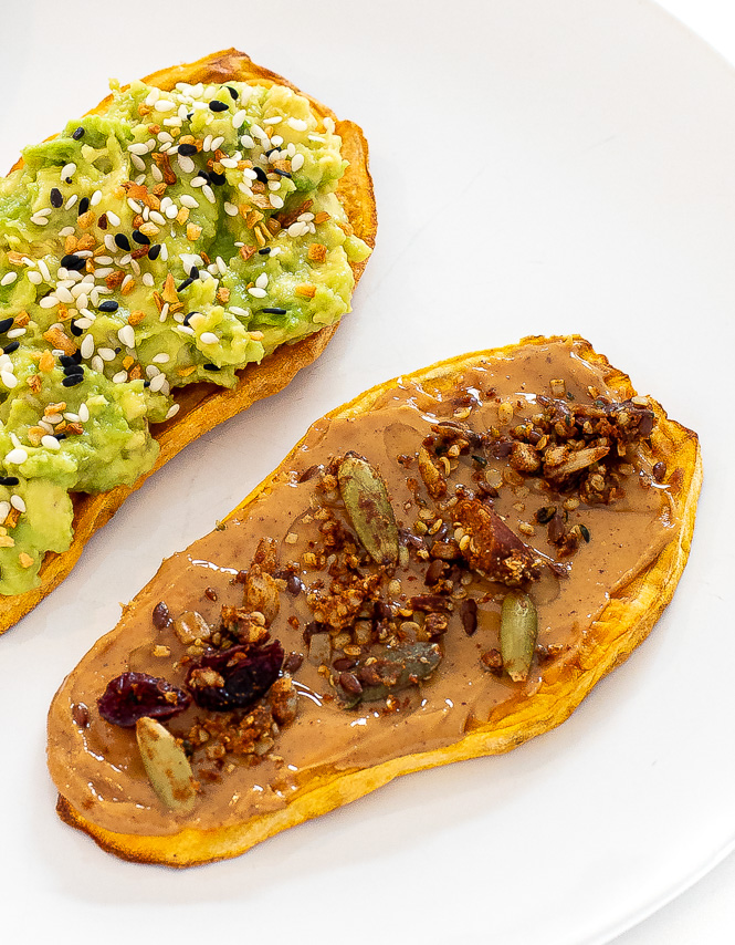 Two slices of sweet potato. One with avocado on top and the other with peanut butter on top.