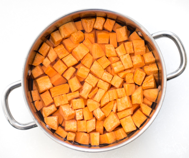overhead shot of cubed sweet potatoes in a large pot of water