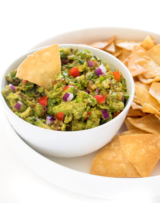 guacamole dip on a tray with homemade tortilla chips