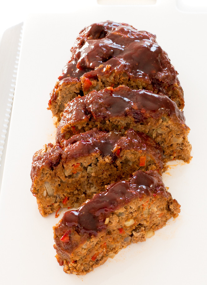 Easy Beef Meatloaf recipe on a white serving dish. Smothered in delicious BBQ sauce.