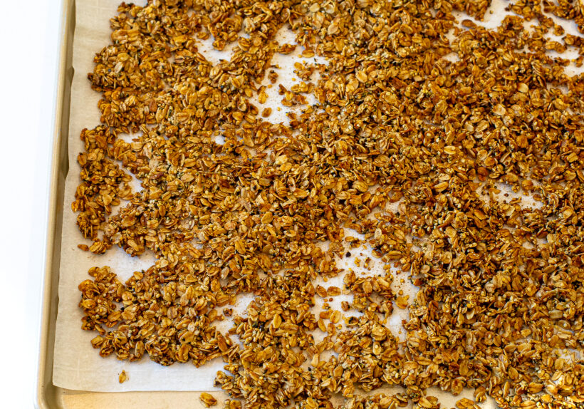 Granola on a baking sheet after being toasted in the oven. 
