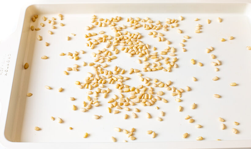 Toasted pine nuts on a baking sheet.