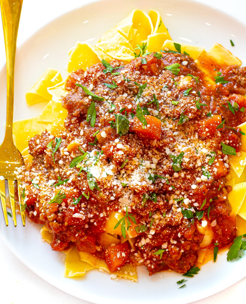 Homemade bolognese sauce served with noodles in a white bowl.