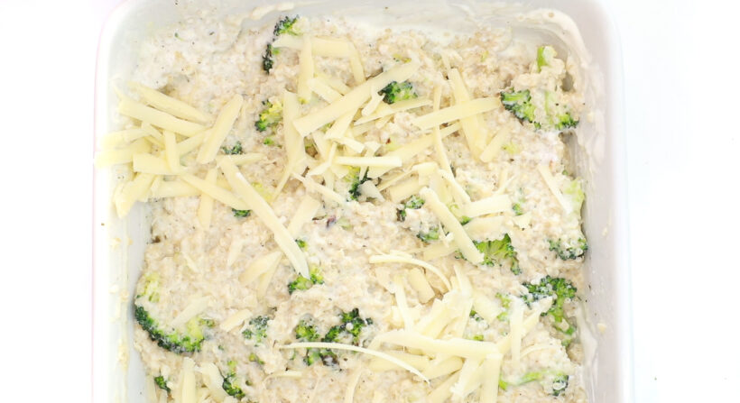 tossing quinoa and broccoli in cheese sauce with sour cream and topping with shredded cheese