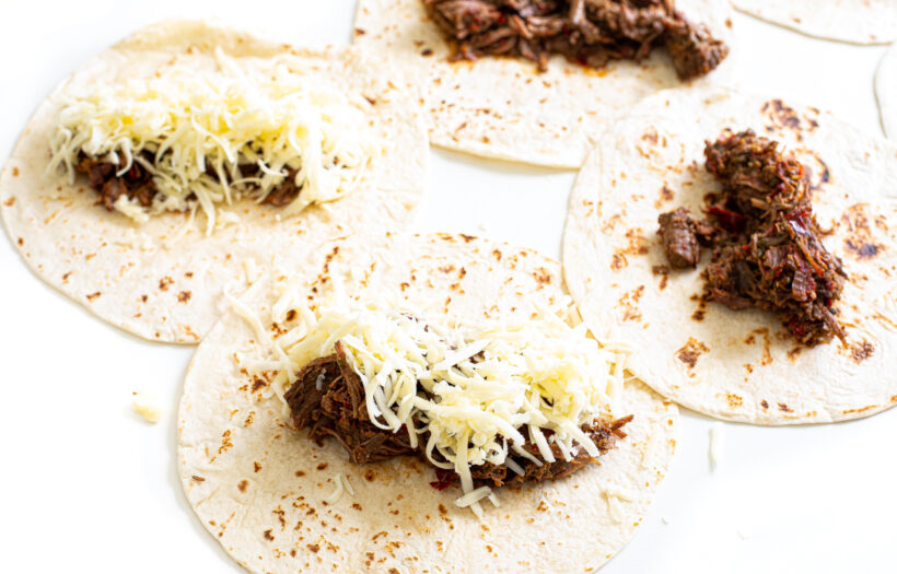 Enchilada ingredients on flour tortillas.