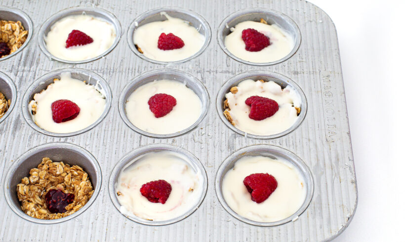 Assembling the white chocolate oat cups in a muffin tin.