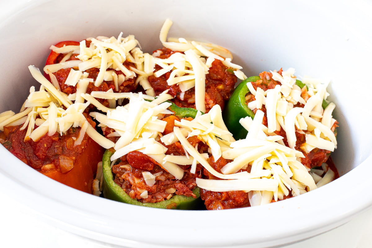 topping unbaked stuffed peppers with shredded cheddar cheese