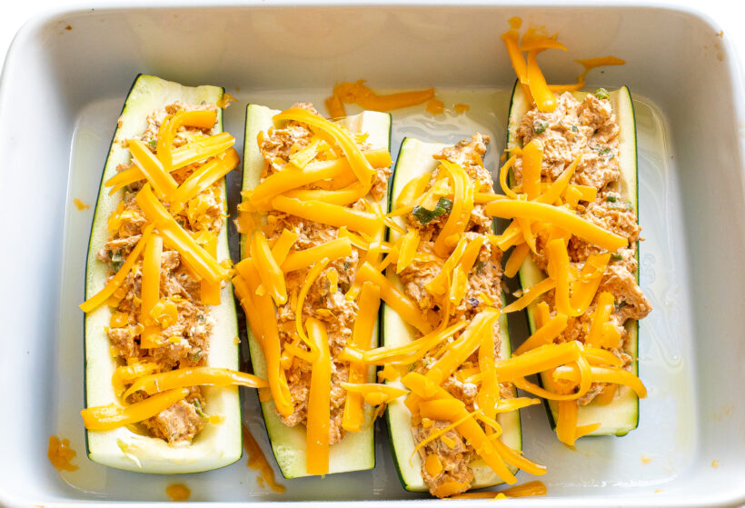Zucchini boats with cheddar cheese sprinkled on top.