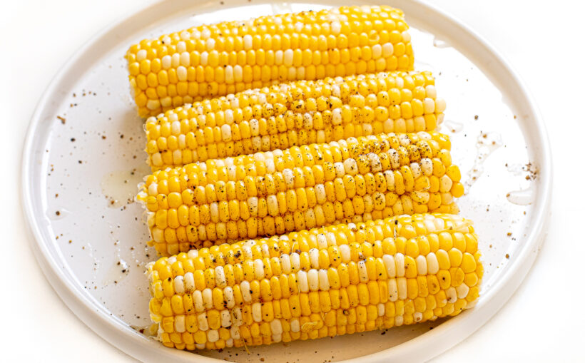 Corn on the cob on a white plate.