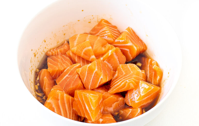 Salmon bites in the marinade before being stirred. 
