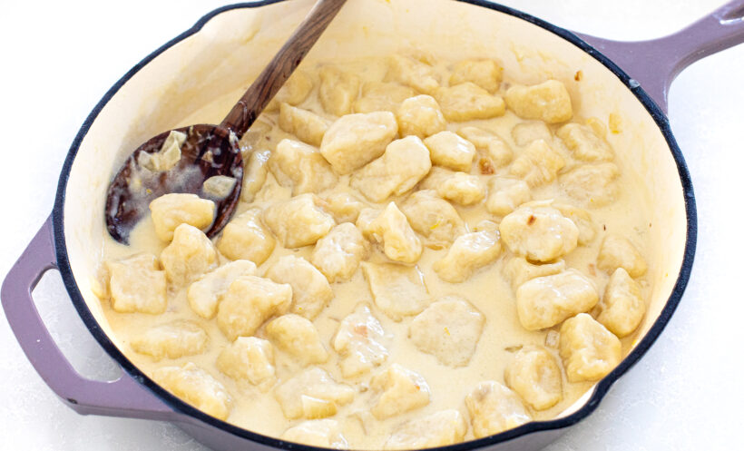Gnocchi in a creamy sauce in a skillet. 
