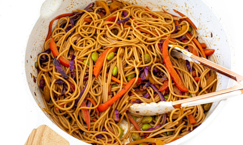 adding noodles to stir fried vegetables