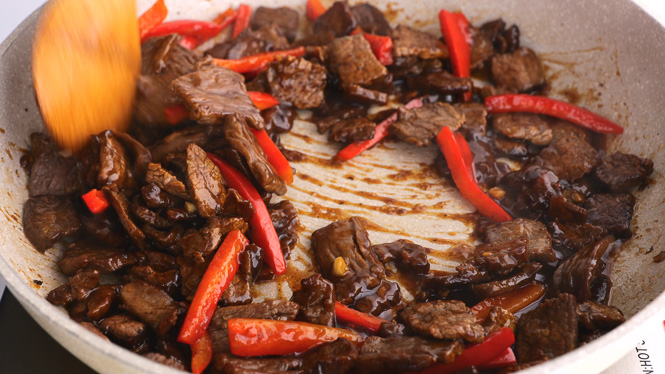 tossing steak in sauce