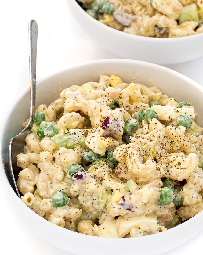Tuna macaroni salad in a white bowl with a silver spoon. 