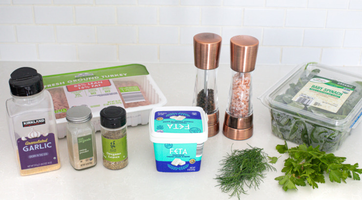 Ingredients needed for Greek turkey burgers on a kitchen counter. 