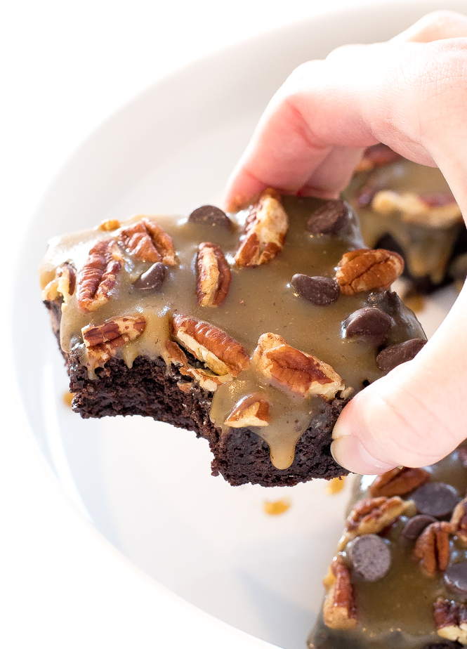 author picking up a brownie topped with a homemade caramel sauce