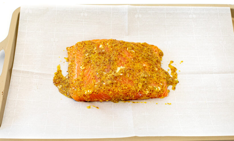 Salmon with honey mustard marinade on it before being baked. 