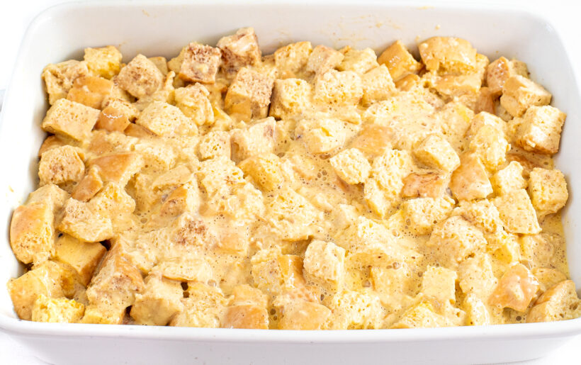 Unbaked eggnog casserole in a white baking dish.