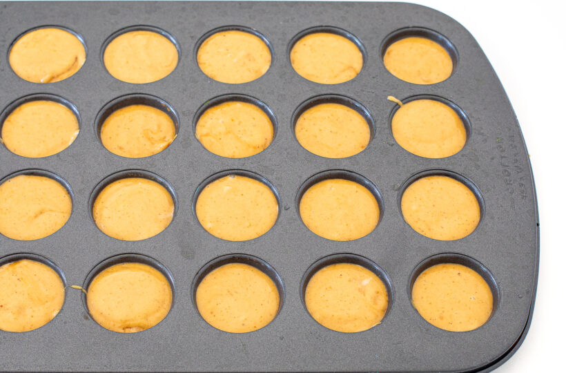 Flourless peanut butter muffin batter in a mini muffin tin. 