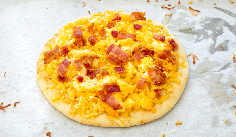 Breakfast pizza assembled before being baked. 