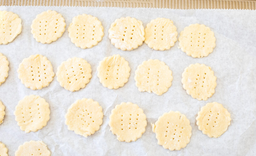 Crackers placed on a parchment paper lined baking sheet.