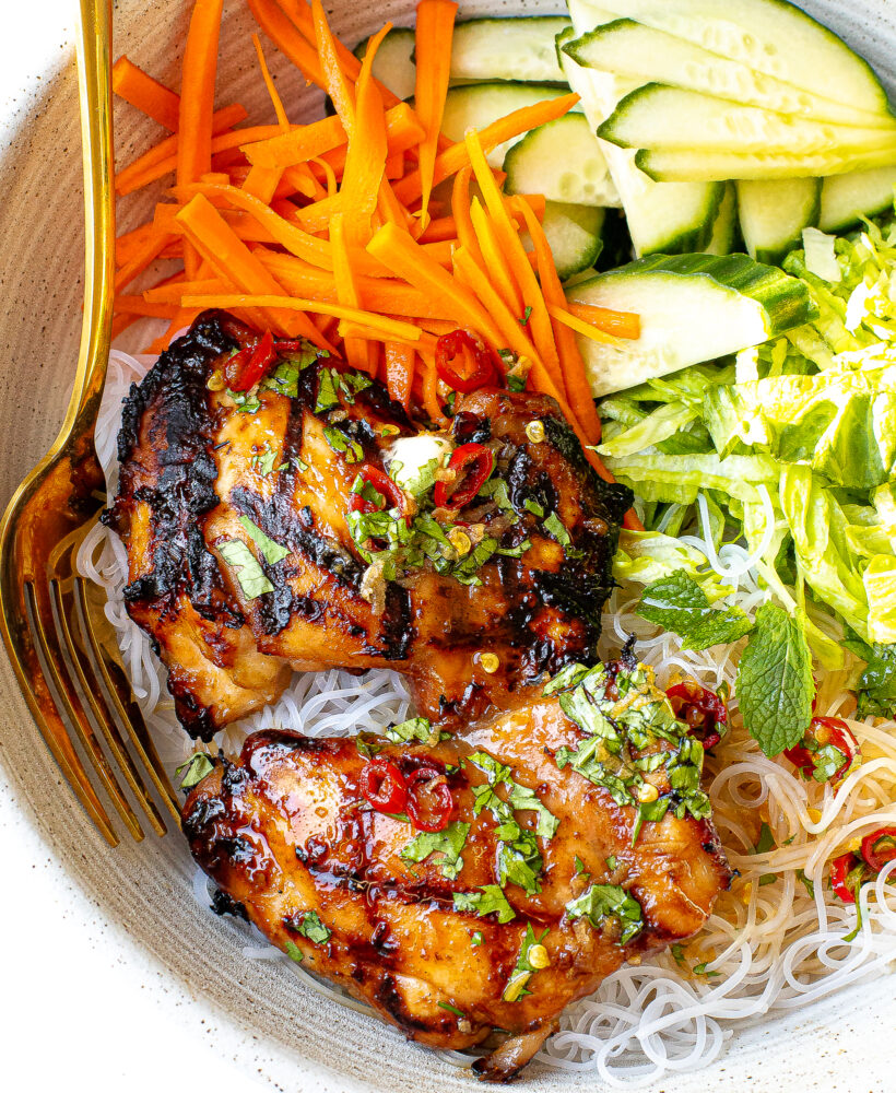 Grilled chicken in a vermicelli noodle bowl with toppings.