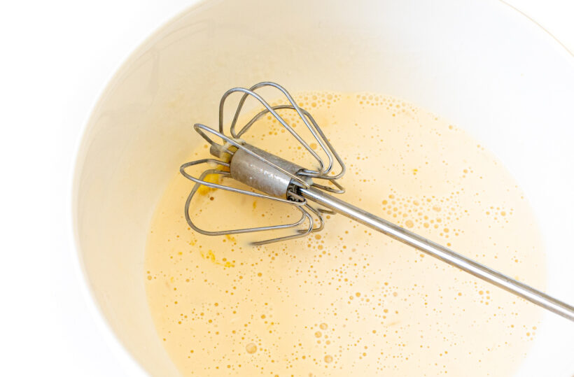 whisking wet ingredients together in white bowl