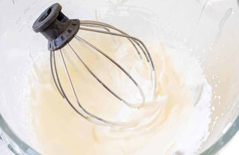 Heavy cream whipped in a mixing bowl.