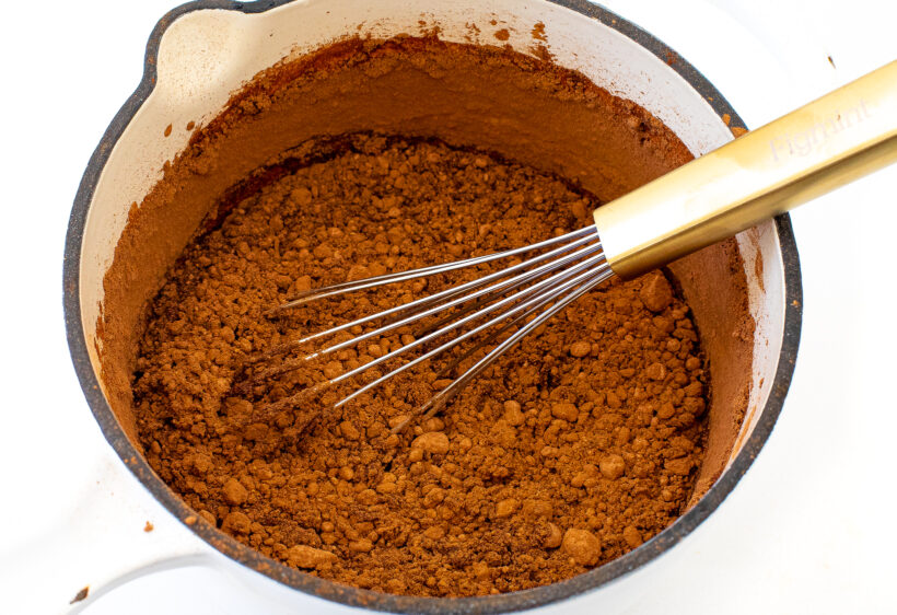 Cocoa powder, sugar and water in a sauce pan before being whisked together. 