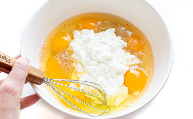 Hand whisking quiche mixture.