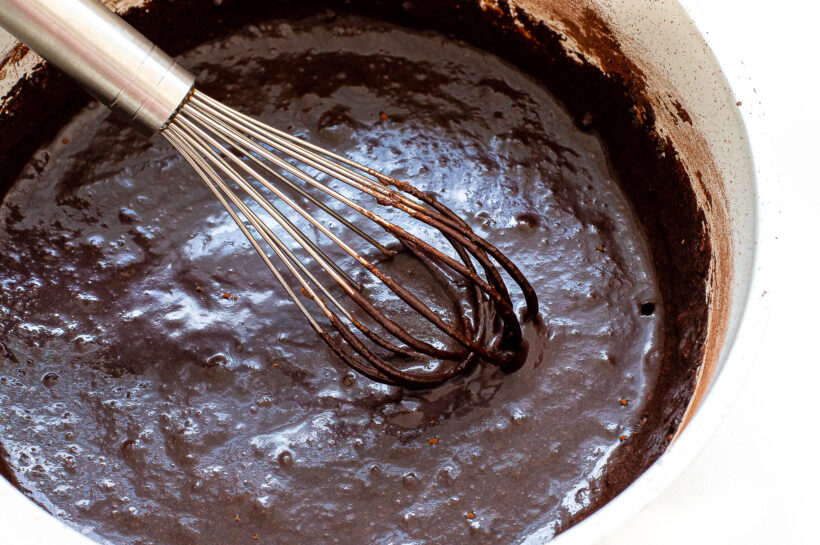 Fudgesicle mixture in a saucepan with a whisk.