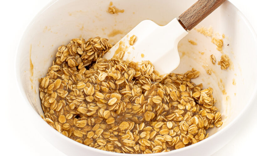 Lace cookie dough being mixed in a mixing bowl with a rubber spatula. 