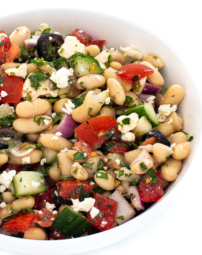 White bean salad in a white bowl.