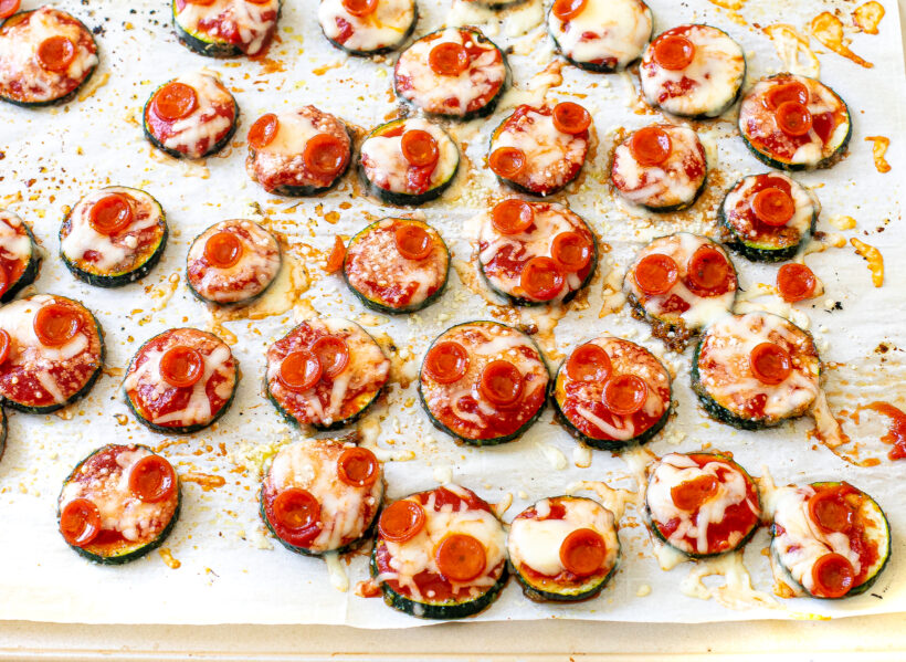 Zucchini pizza bites on a baking sheet after being baked.