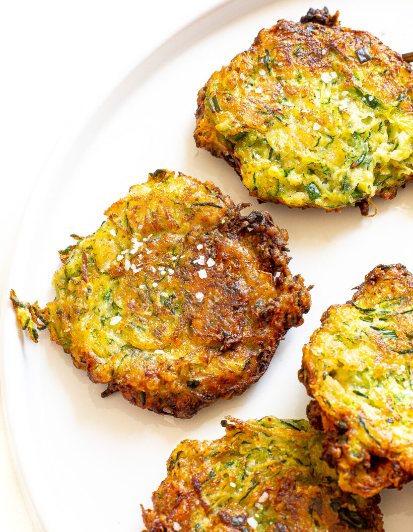 Zucchini fritters on a white plate.