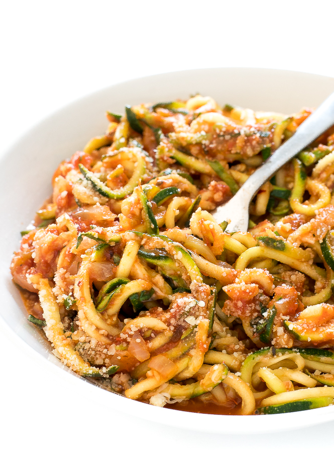 Zucchini Noodles in Tomato Sauce in a white bowl with a fork.