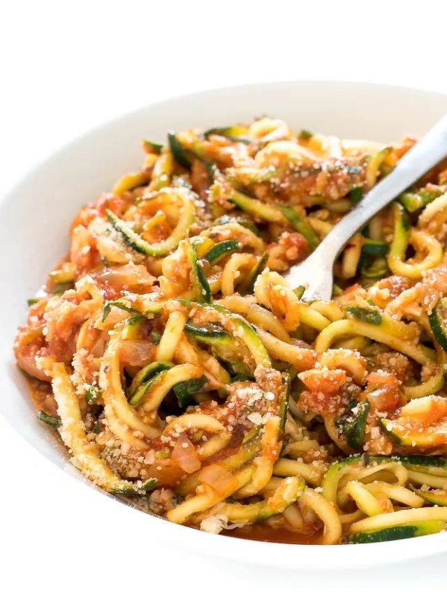 vegetarian zucchini pasta in white bowl topped with parmesan cheese