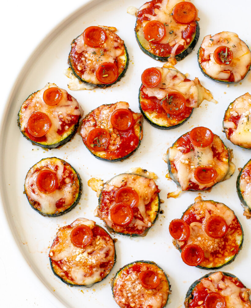 Overhead shot of pepperoni zucchini pizza bites on a plate.